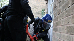 Police wearing helmets and body armour raid a house in Hucknall
