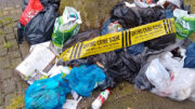 a pile of dumped rubbish with "environmental crime scene" tape