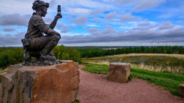 A sculpture of a kneeling miner checking a lamp