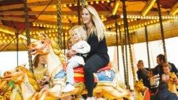 a mother and children on a carousel fairground ride